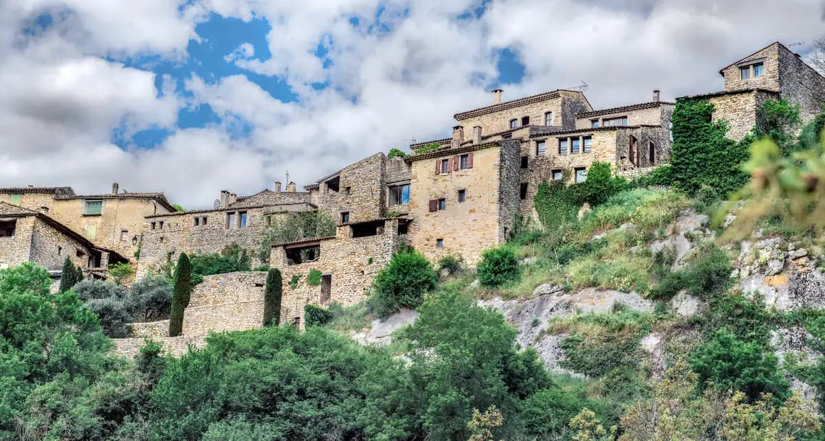 Village perché aux maisons de pierre sèche accroché au flanc d'une colline boisée de l'arrière-pays